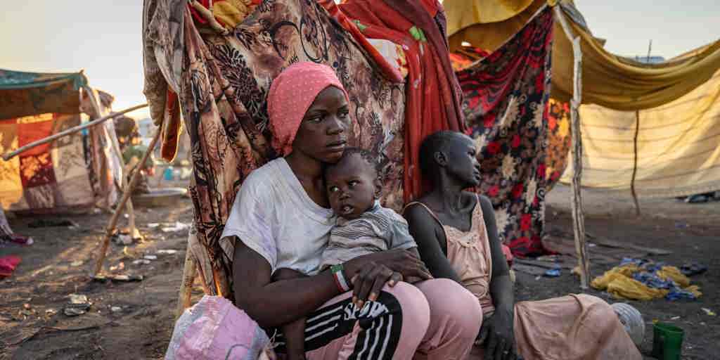 Nyauke, 18, sits with her mother and baby sister at a UNHCR transit centre near the South Sudanese border after fleeing violence in Bentiu, Sudan.