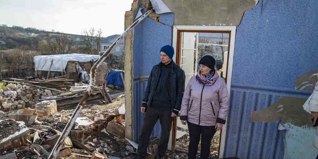 Vitali and his mother Halyna stand in the ruins of a family home following a missile attack on their village, Ukraine