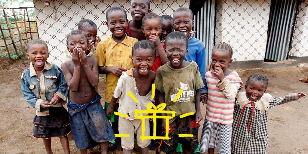 A group of smiling refugee children with a gift emoji superimposed over the image