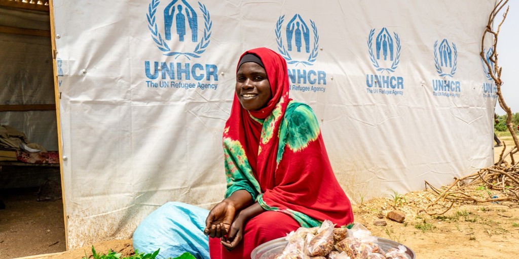 Sudanese refugee Hawa Issat in front of her temporary shelter 