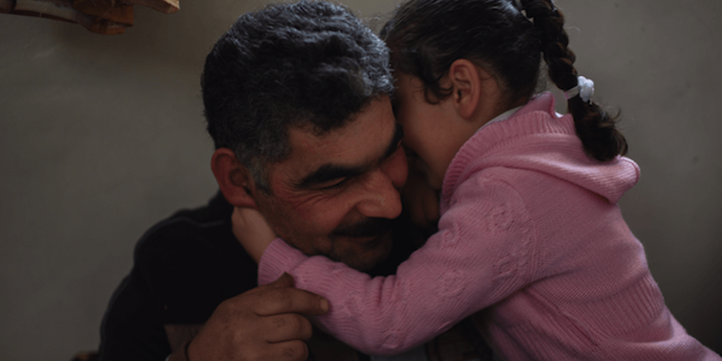 Syrian refugee Mostafa embraces his daughter Rahaf 