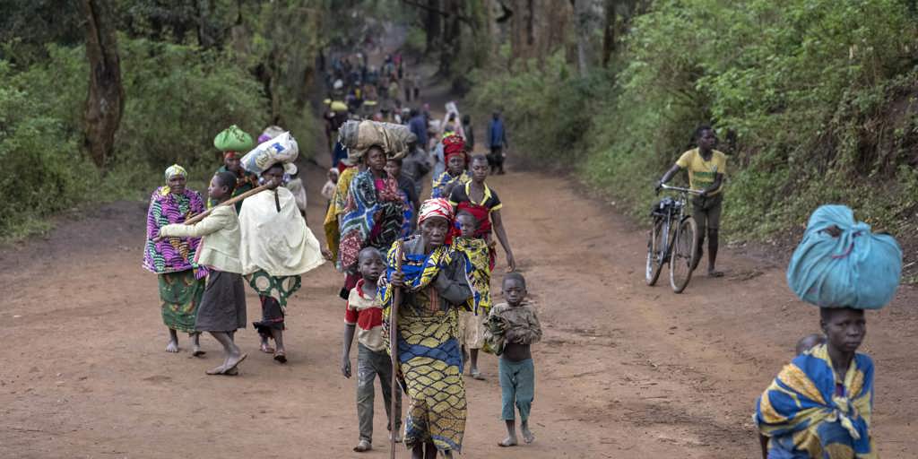 Displaced people walk back to Plain Savo site early morning after spending the night in host families in the nearby city of Bulé.