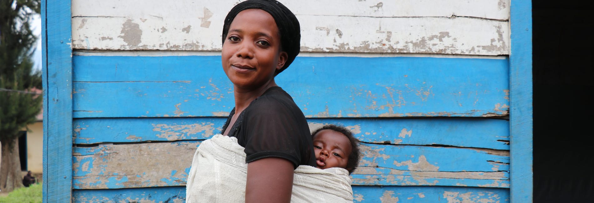 Displaced woman holds baby. In Masisi, Democratic Republic of Congo, UNHCR empowers women to become leaders in their communities 