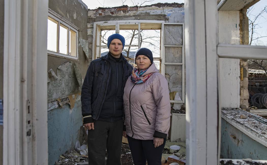 Ukraine. Vitali and his mother Halyna stand in the ruins of their home