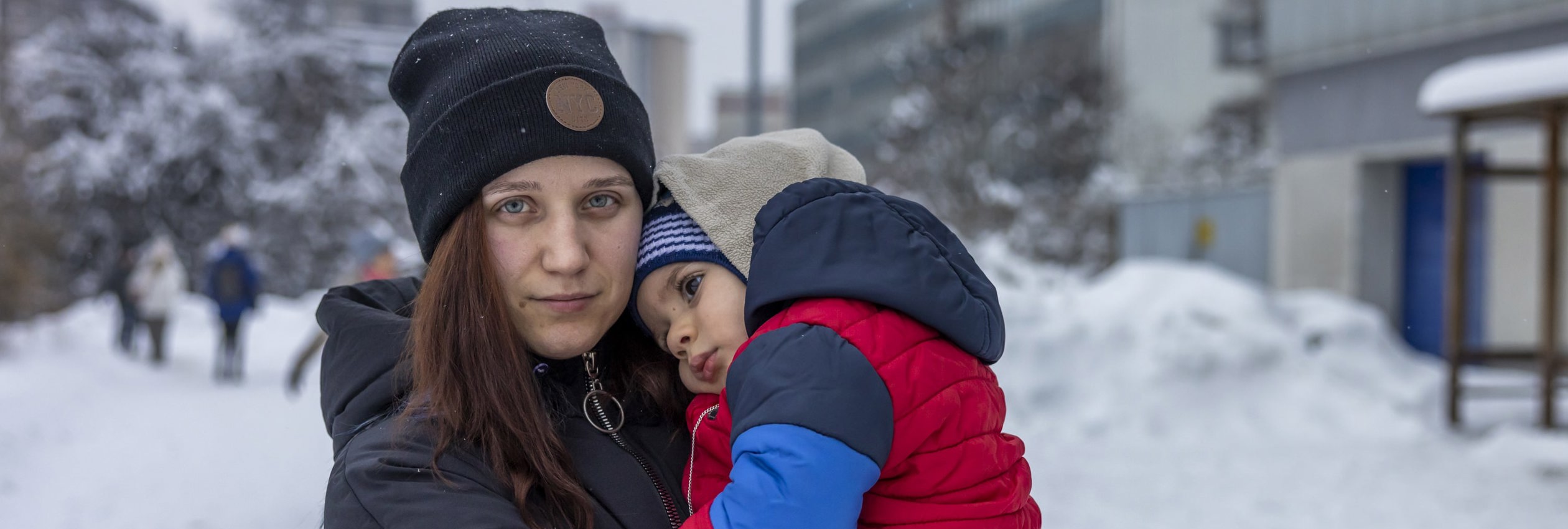 Woman holds child in the snow. Kateryna fled her hometown of Kryvyi Rih in southern Ukraine on 6 March. 