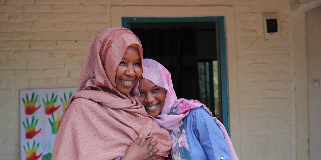 Raina and her daughter Fatima in front of their home at ETM Gashora. ETM Gashora was established in 2019 following the signature of a Memorandum of Understanding (MoU) by the Government of Rwanda, UNHCR and the African Union to rescue refugees and asylum-seekers from Libya, while continuing to search for durable solutions.