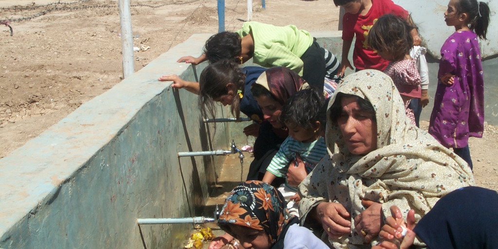Afghan refugees use water taps in a UNHCR refugee camp.