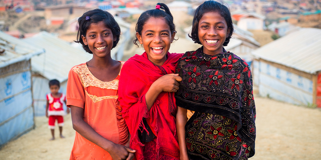Three young girls, smiling at camera. © UNHCR/Roger Arnold