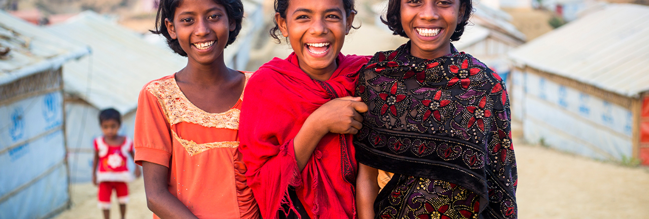 Three young girls, smiling at camera. © UNHCR/Roger Arnold