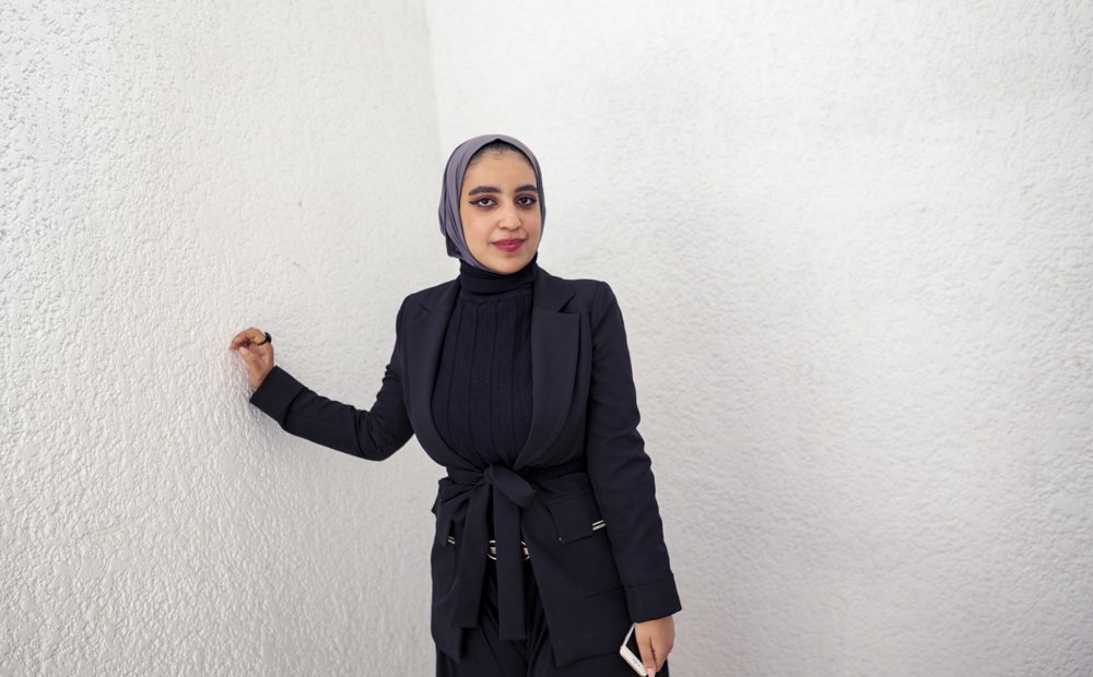 Young woman leans against wall. Fatima, from Yemen is a third-year student of Medicine at Cairo University, on a DAFI scholarship.