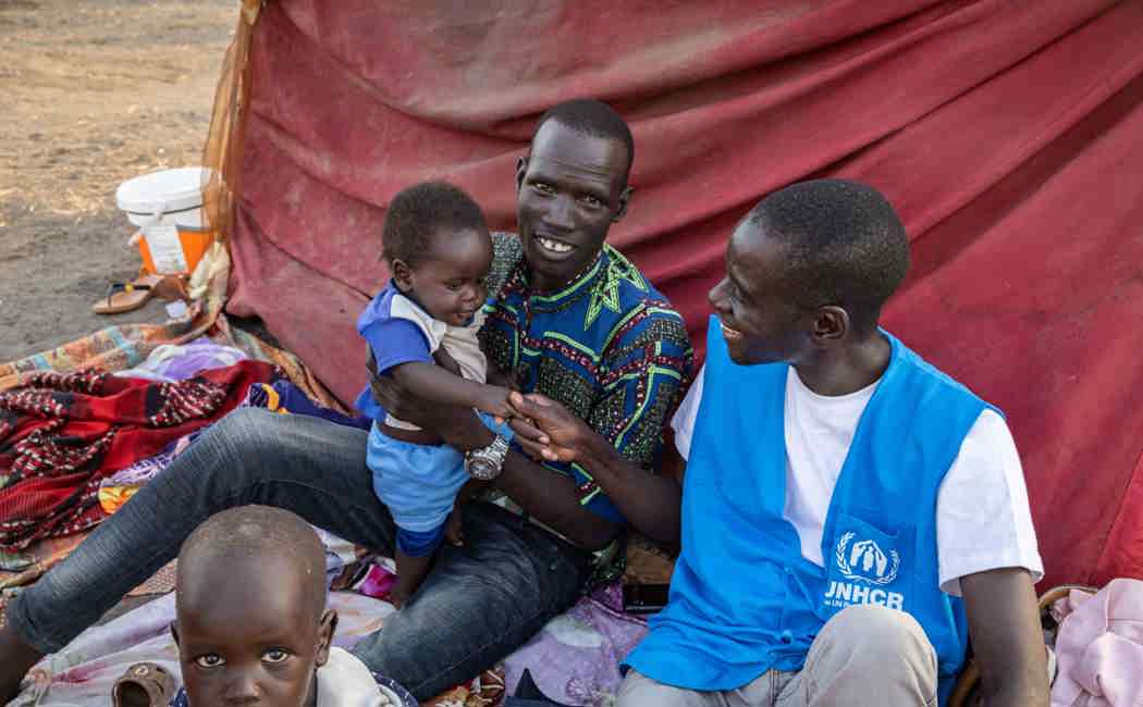  UNHCR Protection Officer Loku James speaks with refugee families at the UNHCR transit centre in Renk, South Sudan. 
