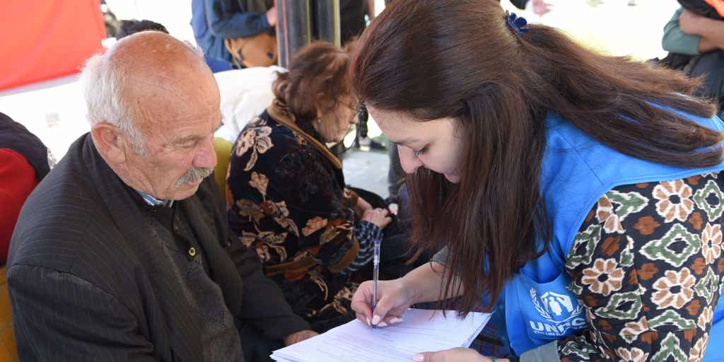 Borik, 75, and his wife Lena, 73, speak with UNHCR staff member Arevig in Goris, south-eastern Armenia, where tens of thousands of refugees have arrived in less than a week.  