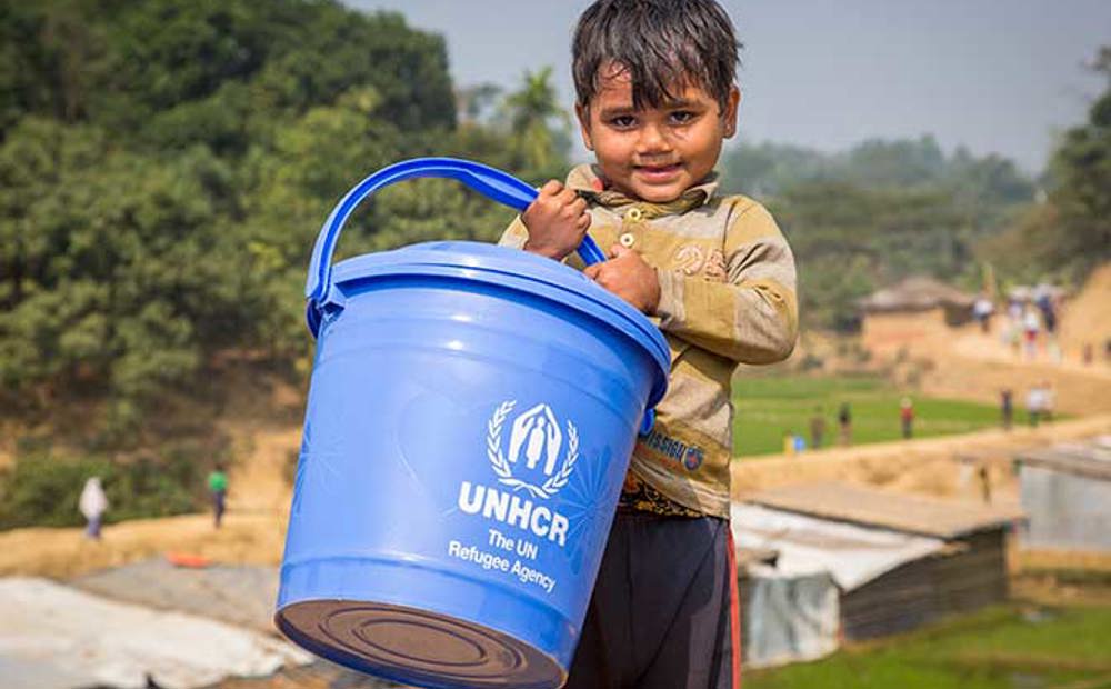Young Rpohingya boy collecting water in his UNHCR bucket in Bangladesh | Ramadan charity gifts