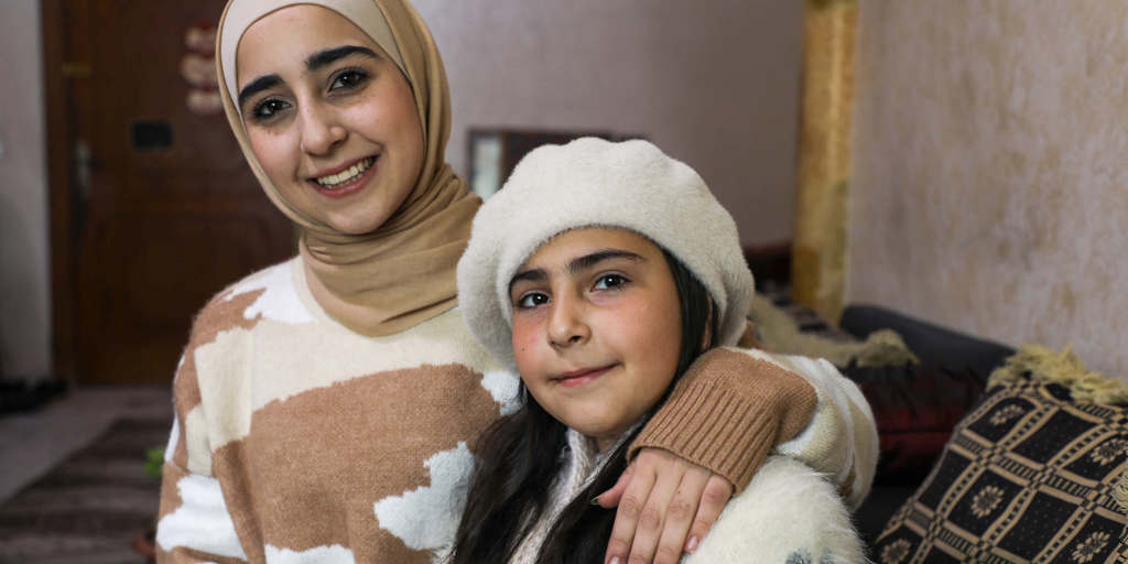 Aya, 20, a Syrian refugee in Jordan is pictured with her younger sister Turkia, 10