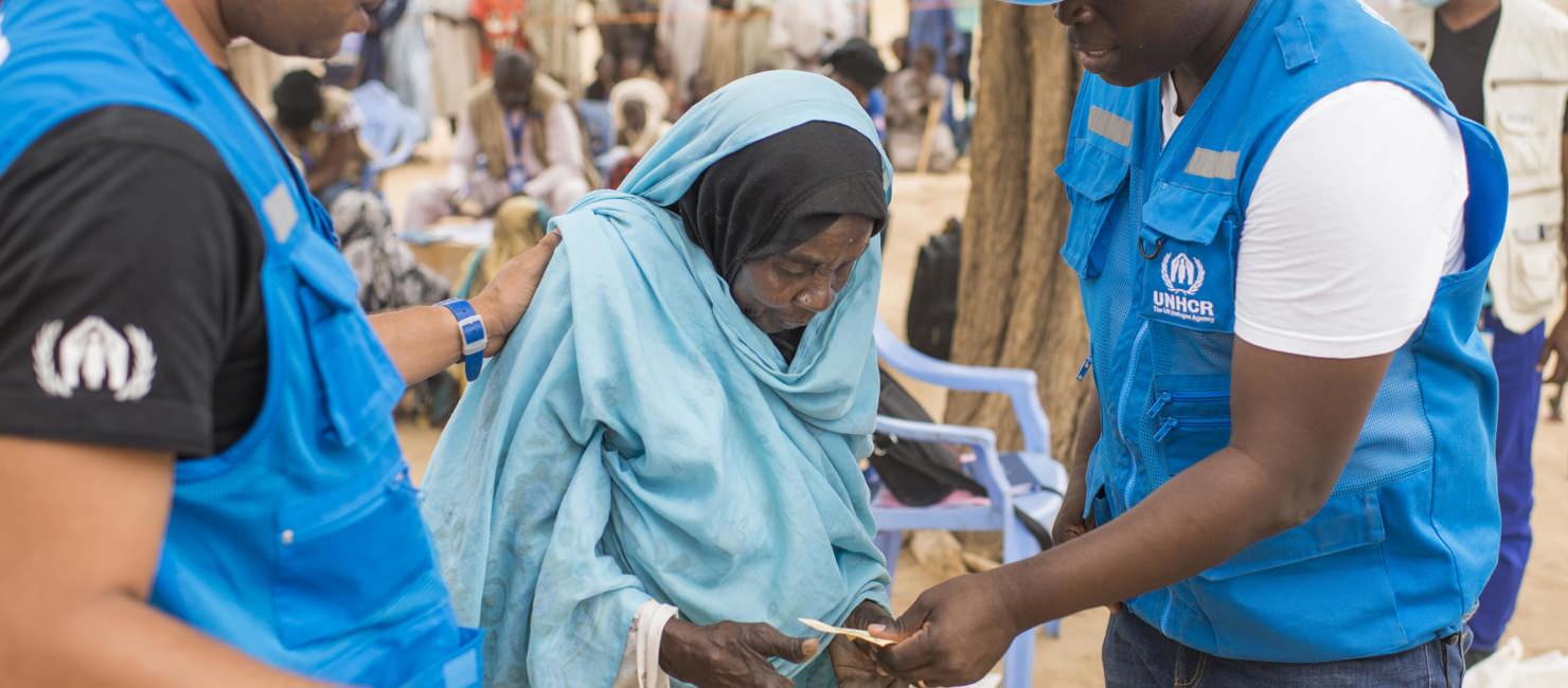 Newly arrived Sudanese refugee, Khadija, 72, receives a UNHCR relief kit at the Madjigilta site in Chad's Ouaddaï region, on the border with Sudan. 