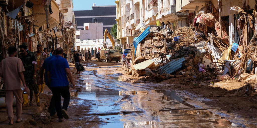 People walk in the mud between the rubbles, after a powerful storm and heavy rainfall hit Libya, in Derna, Libya September 13, 2023.