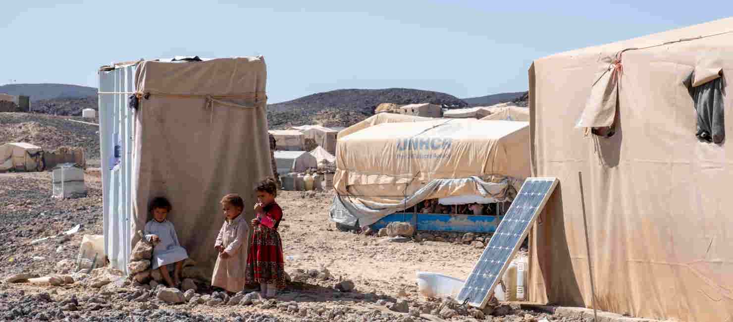 Yemeni children Radad, Arif, and Nazih seek shade at a site for internally displaced people.