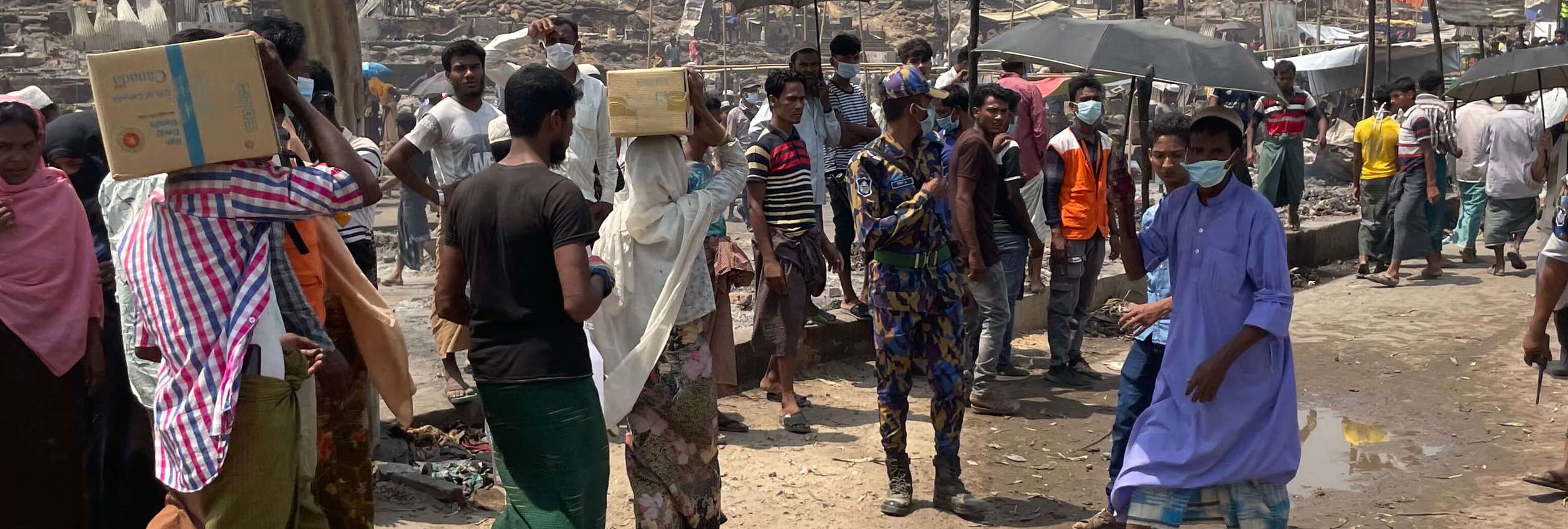Rohingya refugees line up to evacuate burnt down refugee camp.