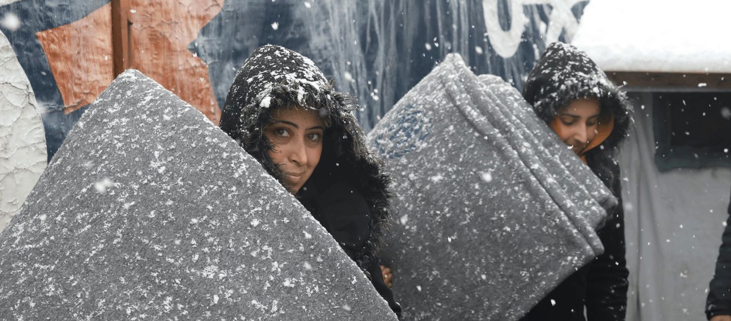 Two women receive thermal blankets as part of UNHCR's winter assistance in Lebanon.