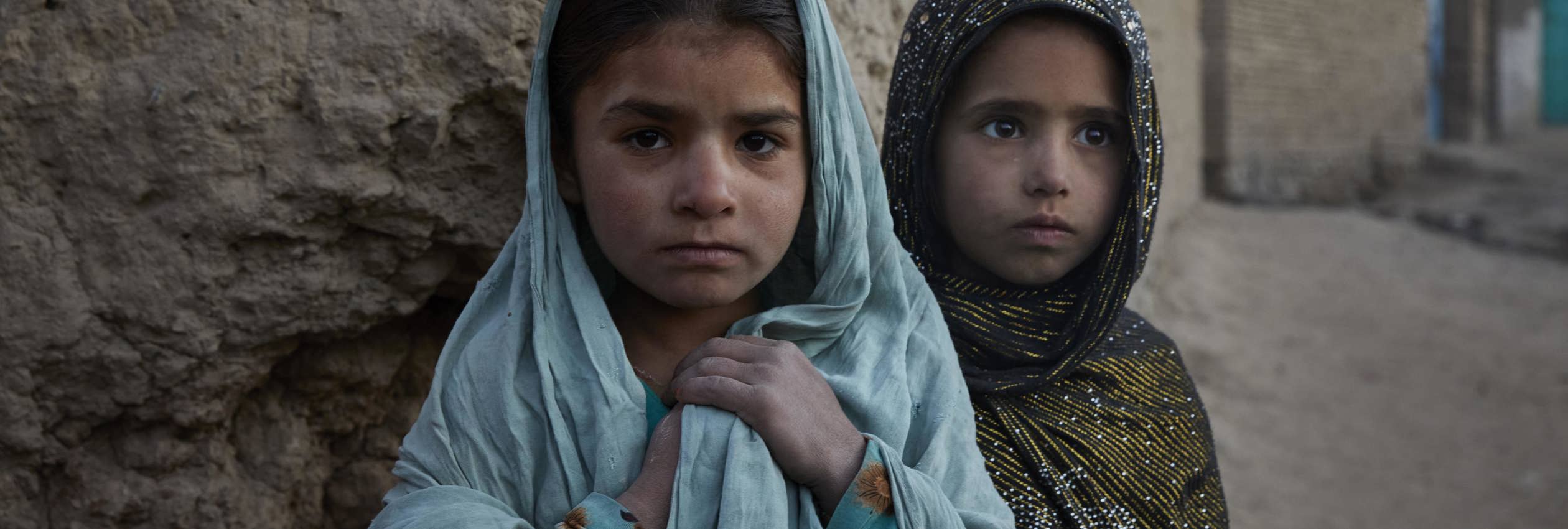 Seven-year-old Runa* from Jalalabad (left) and her friend Gul Bibi*, 7, from Kunduz, in their new neighbourhood on the edge of Kabul.