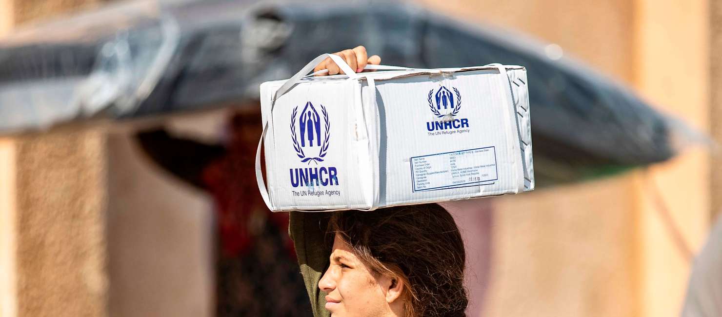 Displaced Syrians, who fled their homes in the border town of Ras al-Ain, receive humanitarian aid on October 12, 2019, in the town of Tal Tamr in the countryside of Syria's northeastern Hasakeh province.