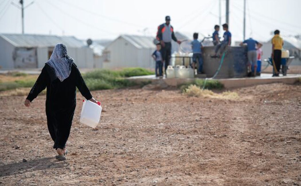 Um Hadi collects her daily allocation of water in Azraq camp.