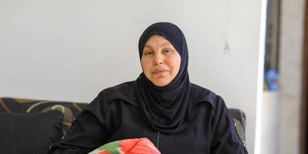 Khloud, Syrian refugee in Jordan holds blanket