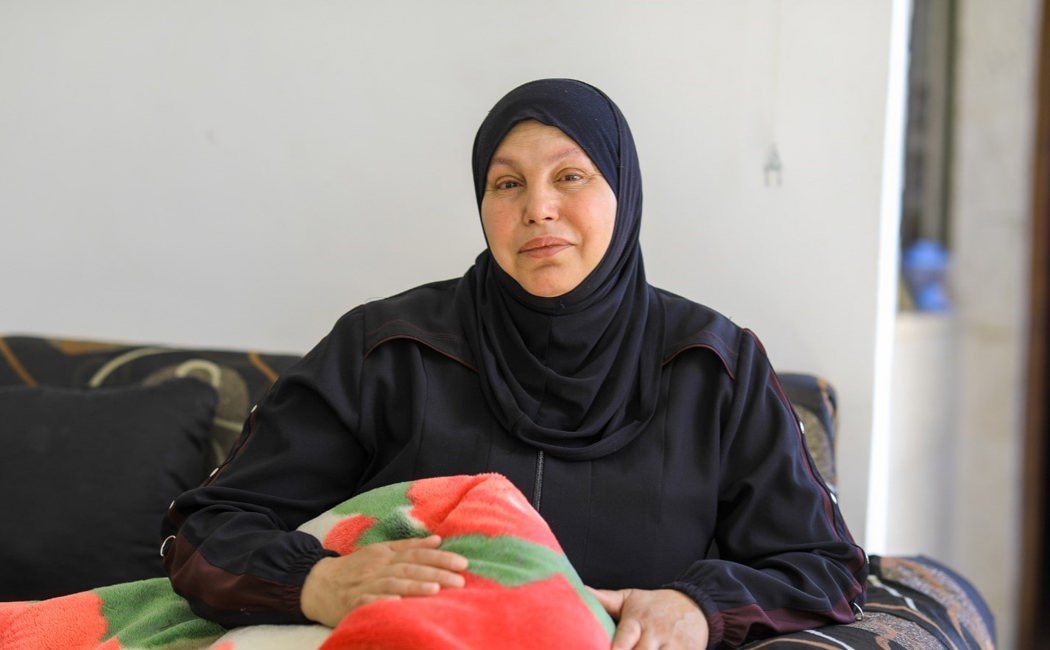 Khloud, Syrian refugee in Jordan holds blanket