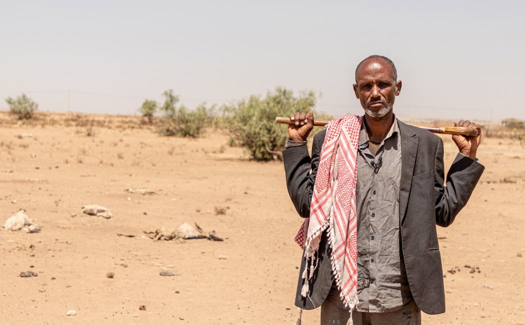 Displaced person, Abdullahi stands facing camera. He was forced to leave his wife and seven children behind in their village. 