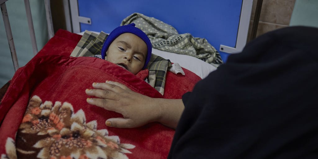 Eight-month-old Barkatullah*, who is suffering from malnutrition, is comforted by his mother Zarbibi at Indira Gandhi Children's Hospital in Kabul.