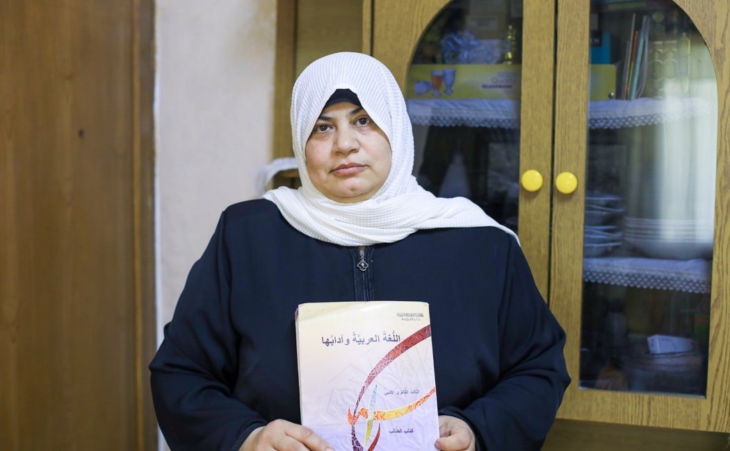 Eman, Syrian refugee in Jordan holds a book