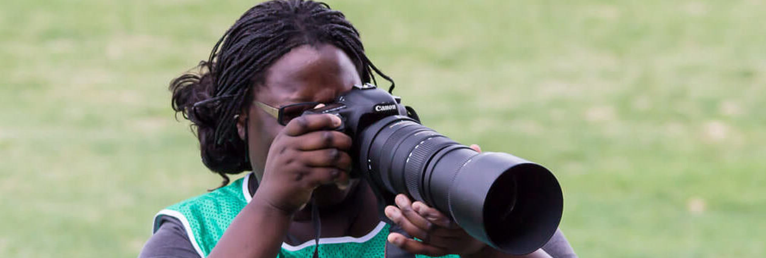 Australian sports journalist Ann Odong takes photos at a sports field