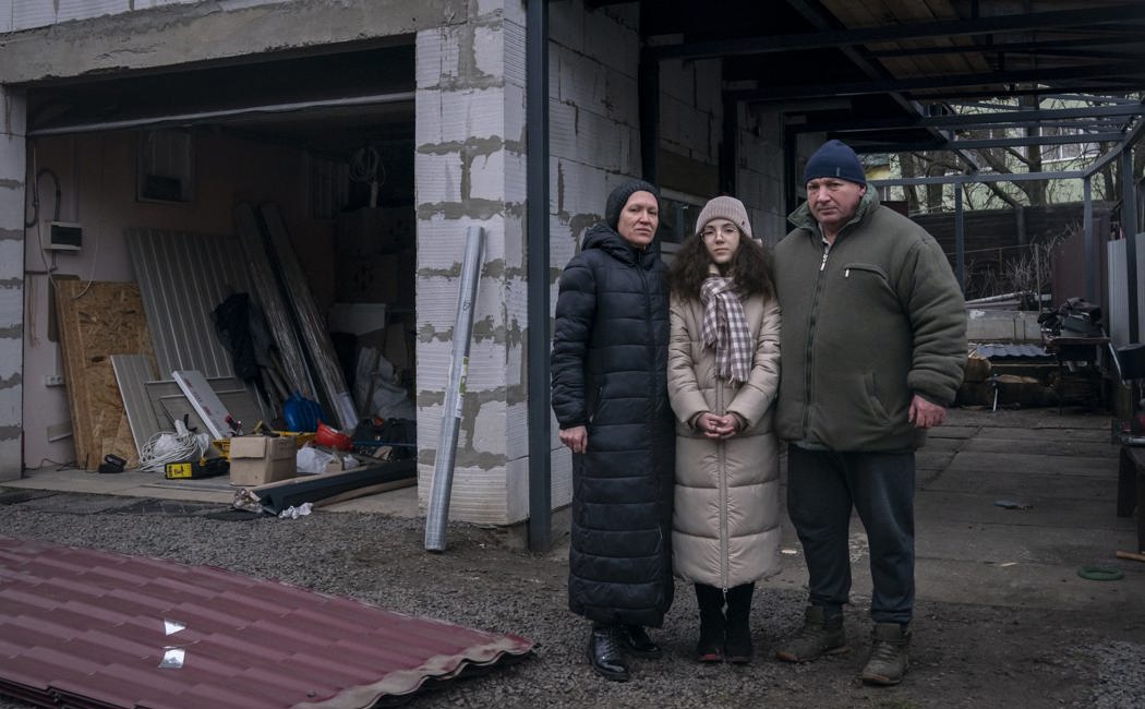 Olena, 50, Andrii, 51, and their daughter, Bohdana, 10, stand in the backyard of their home, in Borodyanka, Kyiv region. 
